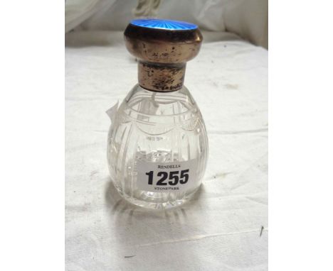 An early 20th Century cut glass scent bottle with silver and engine turned enamel lid - a/f and lid in need of re-attaching