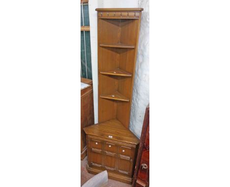 A 68cm Ercol dark elm three shelf corner unit with cupboard to base, set on plinth base - 1.98mn high