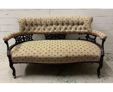 An Edwardian two seater salon sofa, button backed and upholstered in a scrolling floral pattern AF