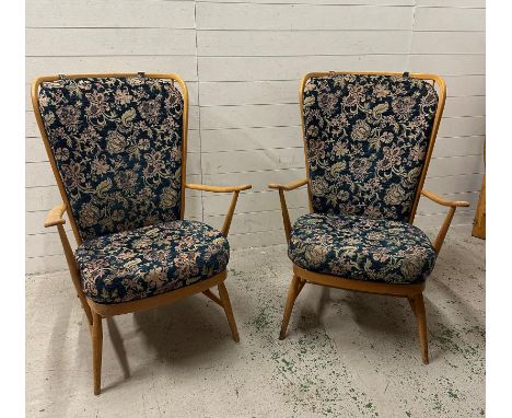 A pair of blonde Ercol stick back chairs upholstered in a blue floral pattern 