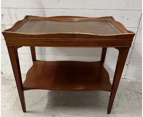 A green leather topped side table with raised rim and shelf under (H57cm W64cm D44cm)