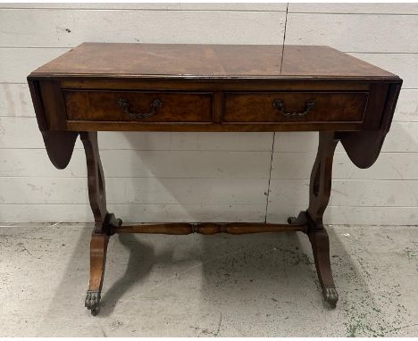 A flame mahogany veneered drop leaf sofa table with two drawers and turned streacher on brass lions paw feet. Height 75 87x55