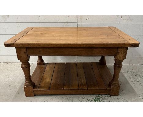 A light oak coffee table on turned supports with shelf under (H47cm W91cm D58cm)