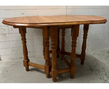 A oval pine gate legged drop leaf dining table (H75cm W129cm D91cm)
