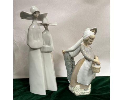 Two Spanish ceramic figures of a boy and a girl and two nuns 