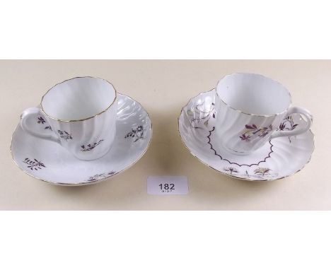 A pair of early 19th century coffee cups and saucers with sprigged floral decoration in manganese and gilt