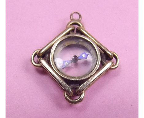 A yellow metal compass fob