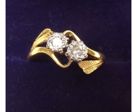 An 18 carat gold and platinum set diamond crossover ring - size N