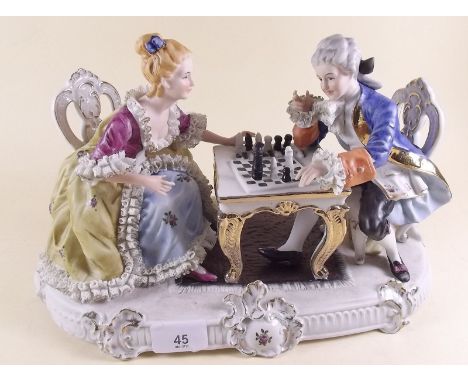 A large porcelain group in 18th century style lady and gent playing chess - 35cm