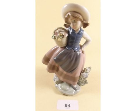 A Lladro figure of a girl holding a basket of flowers - boxed