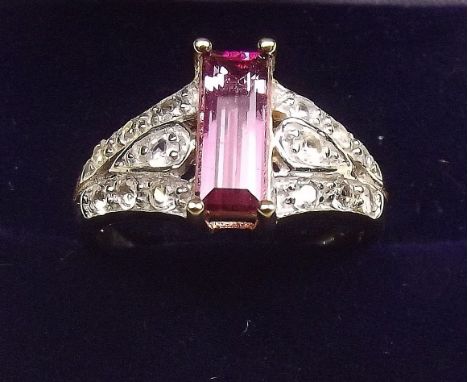 A 9K gold pink tourmaline ring on diamond set shoulders, size O