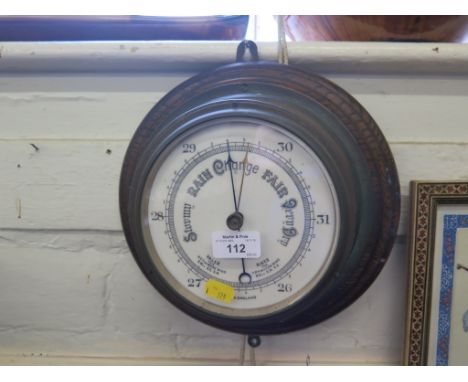 An oak and brass aneroid barometer, circular with ceramic dial, 28cm diameter