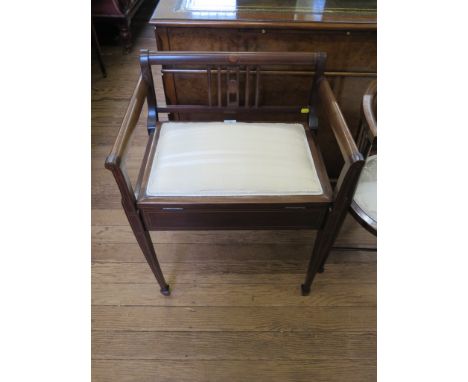 An Edwardian mahogany and boxwood lined piano stool, the raised back with maple panels over a hinged seat and square section 