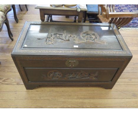 A Chinese camphorwood chest of rectangular form carved with pagodas, figures and boats on stepped bracket feet, 101cm x 52cm 