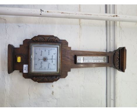 A 1920's oak barometer, of angular form with foliate carving and thermometer, 58cm high