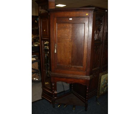 AN OAK CORNER CUPBOARD ON A BOBBIN TURNED BASE