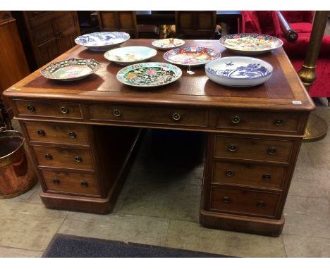 A 19th century mahogany pedestal with inset top, having nine drawers with brass ring handles, 137cm wide x 98cm deep