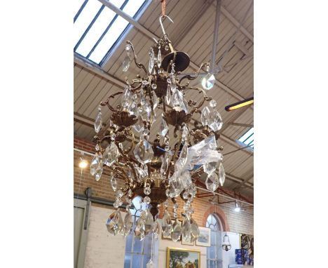 A BRASS SIX LIGHT ELECTROLIERof 18th Century style, with floral sconces, scrolled arms and hung with prismatic drops, 45cm di
