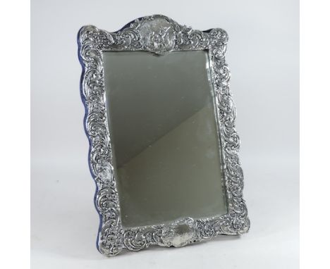 A decorative silver painted vanity mirror, 48 x 32cm overall