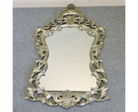An ornate silver painted Rococo style wall mirror, 139cm x 80cm overall 