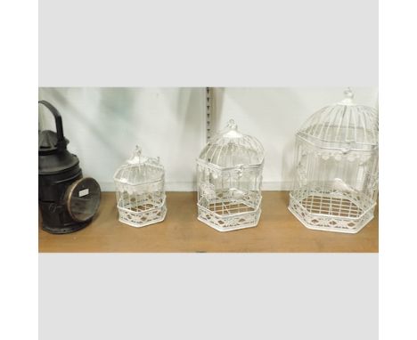 A set of three white painted metal bird cages, tallest 40cm, together with a vintage railway signal lamp 