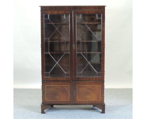 A reproduction glazed bookcase, 85cm, together with an oval wall mirror