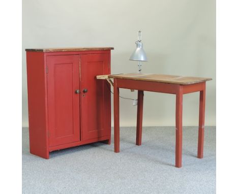 An antique pine and red painted cupboard, 90cm, together with a work table with lamp attached