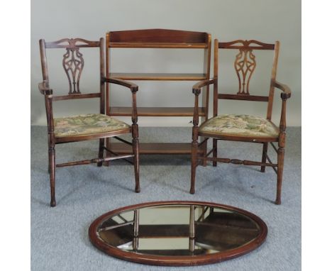 A pair of Edwardian walnut and tapestry upholstered armchairs, together with an open bookcase and an oval wall mirror, 90 x 5