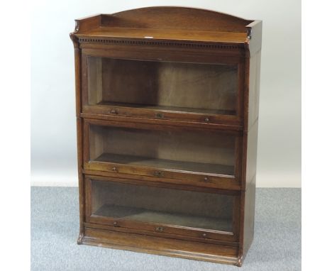 An early 20th century Globe Wernicke style oak glazed three tier sectional bookcase, bearing a label for The Lebus Bookcase, 