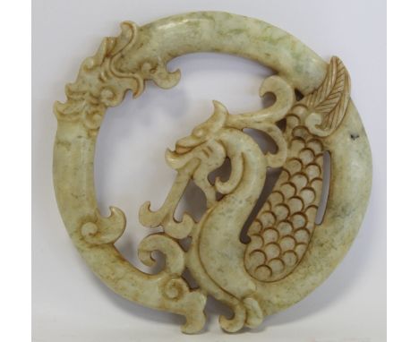 Chinese pierced and carved white and green mottled jade circular panel in the form of a curled dragon with some traces of gil