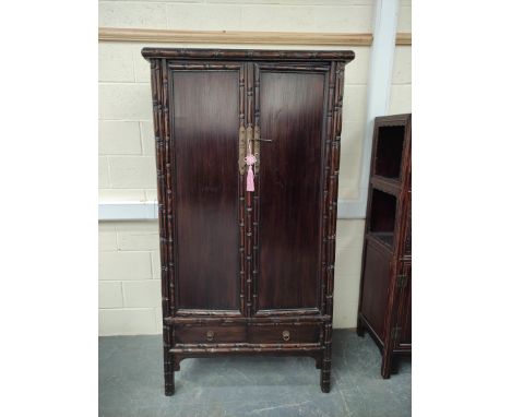 Antique Chinese lacquer cabinet, With two large doors enclosing a shelved interior, above two small drawers with bamboo decor