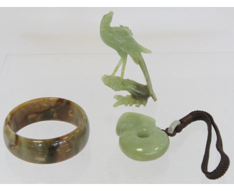 Three pieces of modern Chinese jade, comprising: small carved figure of a phoenix on a branch, 9.5cm high; a bangle of plain 