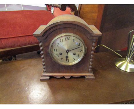 A 1930's oak mantel clock with bobbin design sides, silvered Arabic dial 