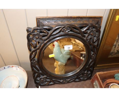 A carved frame mirror and a print of a sampler