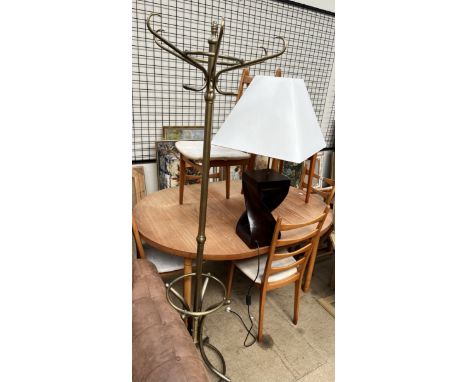 A brass coat and stick stand together with a table lamp 