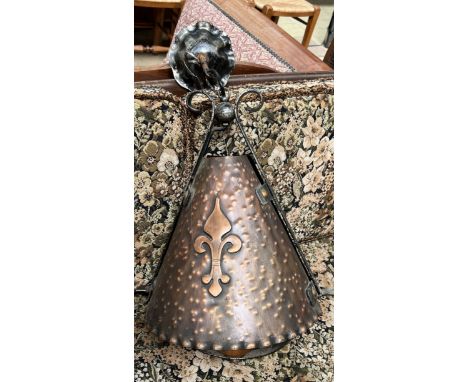 A copper ceiling light of conical shape and wrought iron support 