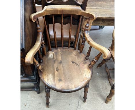 A captain's chair with a stick back and arms on a circular seat and ring turned legs