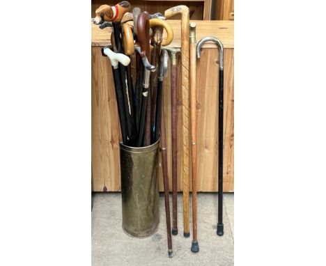 A collection of walking sticks and a brass stick stand 