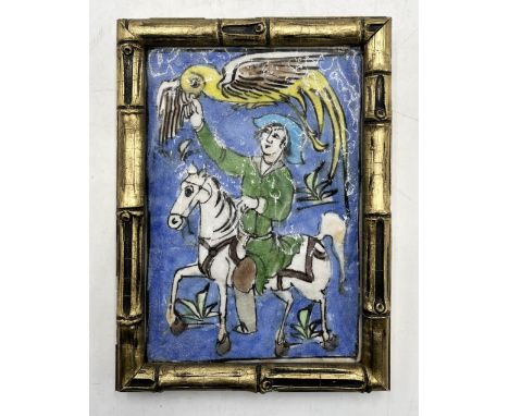 A gilt framed Persian style pottery tile with figure of a horse on blue background