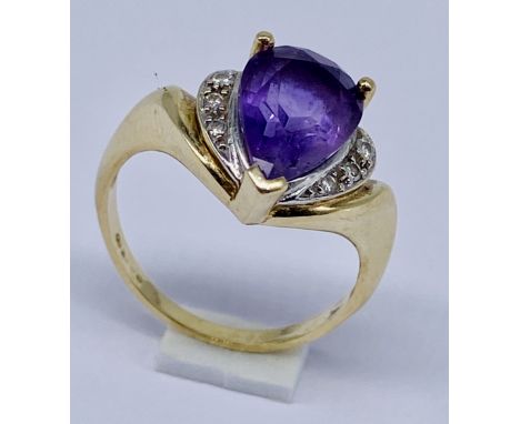 A 9ct gold ring set with a teardrop shaped amethyst and diamonds, size O