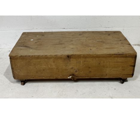 A low rustic pine trunk/toolbox on castors