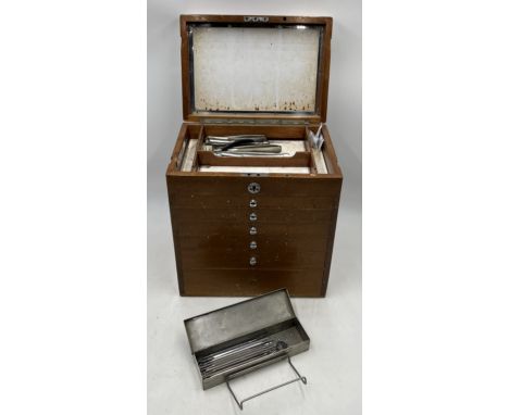 A vintage dentists medical set of drawers containing various tools and equipment