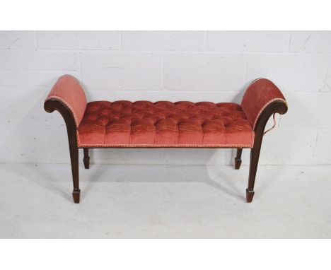 An Edwardian style red upholstered window seat, with button-back detailing, raised on tapered legs with spade feet - length 1