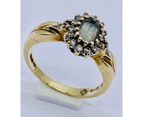 A 9ct gold cluster ring set with diamonds surrounding a pale aquamarine, total weight 3.4g, size M