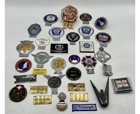 A collection of vintage car grill badges including Woolbridge Motor Club, Seven-Fifty Motor Club, Exmouth Motor Club, Armstro