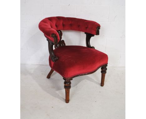 A Victorian mahogany framed upholstered tub chair, with button-back detailing and fretwork detailing to back splat, raised on