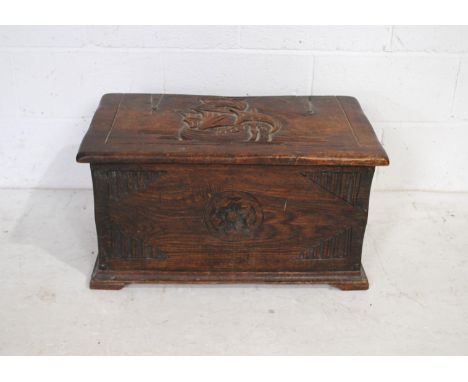 A carved oak trunk of small proportions - length 71.5cm, depth 40cm, height 38cm