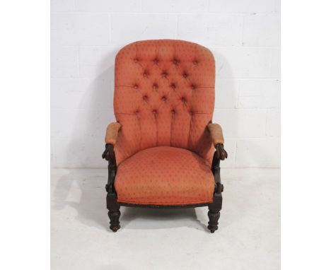 A Victorian mahogany framed upholstered armchair, with button-back detailing and carved decoration