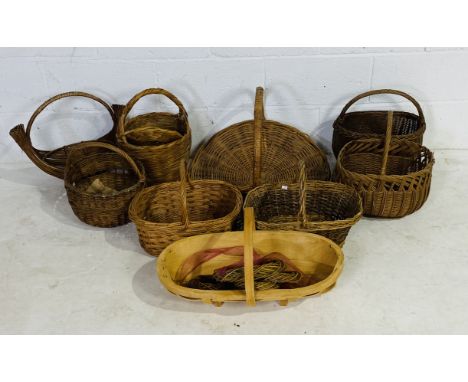 A collection of various wicker baskets, along with a wooden trug