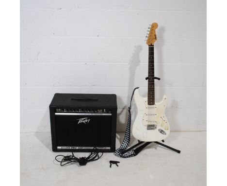 A Fender Squire Bullet Strat electric guitar, along with a Peavey Studio Pro 112 65 watt amplifier, 1/4 jack lead, capo, stra